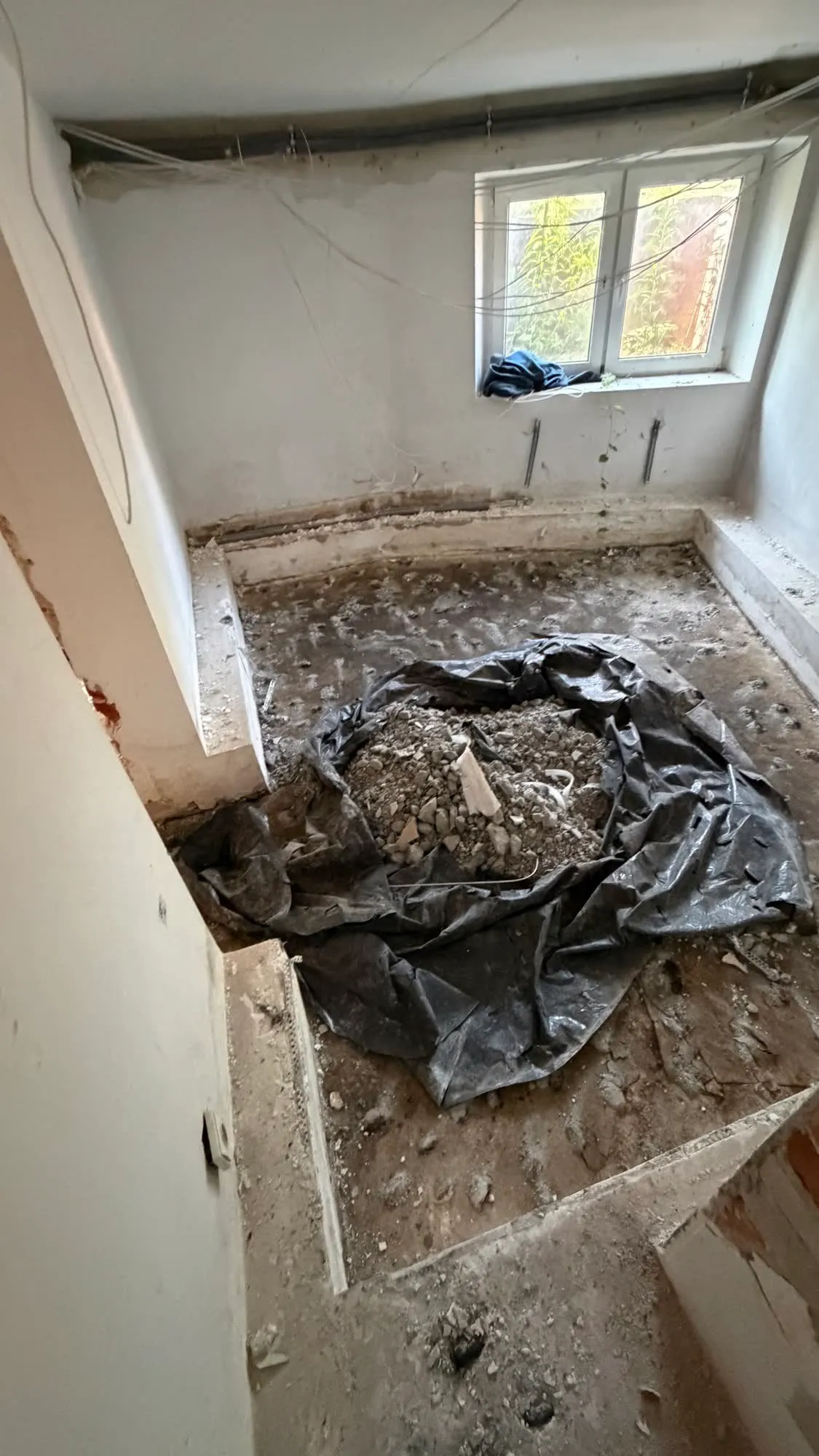 Gruz zsypany na rozłożoną folię ochronną na środku pomieszczenia